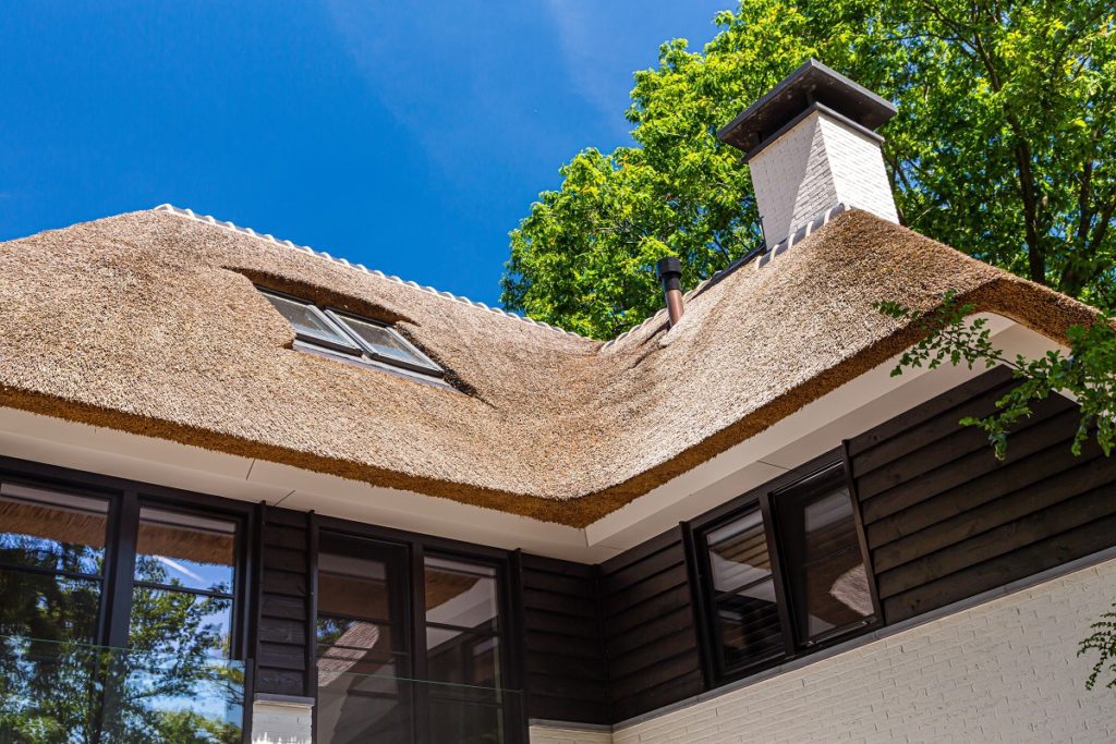 Detail rieten dak en zwarte geveldelen bij rietgedekte villa gebouwd door Lichtenberg Exclusieve Villabouw