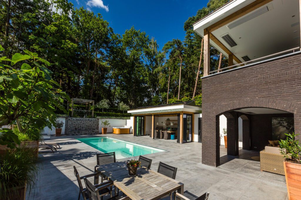 Buitenruimte met zwembad, overdekte veranda en jacuzzie bij villa gebouwd door Lichtenberg Villabouw