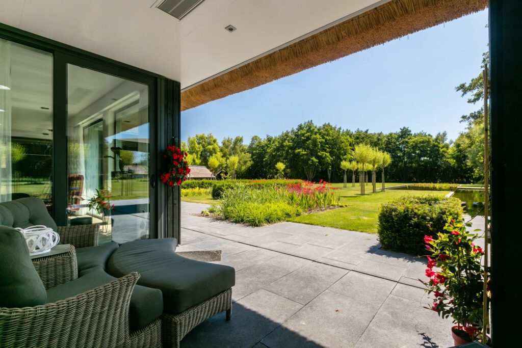 Overdekt terras en uitzicht tuin van villa gebouwd door Lichtenberg Villabouw